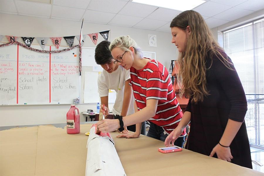 Art club vice-president Brooke Checketts paints a life-size paint brush to decorate for the Homecoming parade. Art club meets each Tuesday afternoon in Julie Winstons room.