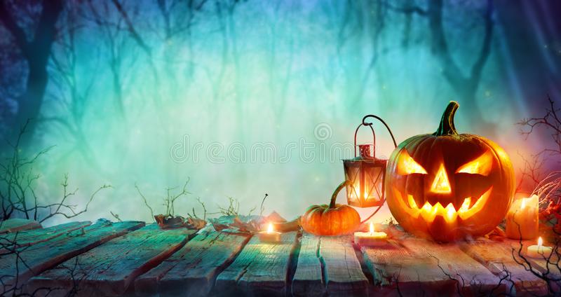 halloween-jack-o-lanterns-candles-table-misty-night-125930601