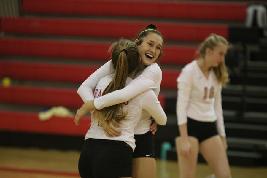 Successfully getting a point, sophomore Katelyn Krienke cheers with members of her team. The volleyball team plays against Hendrickson, another win needed to get to playoffs. 