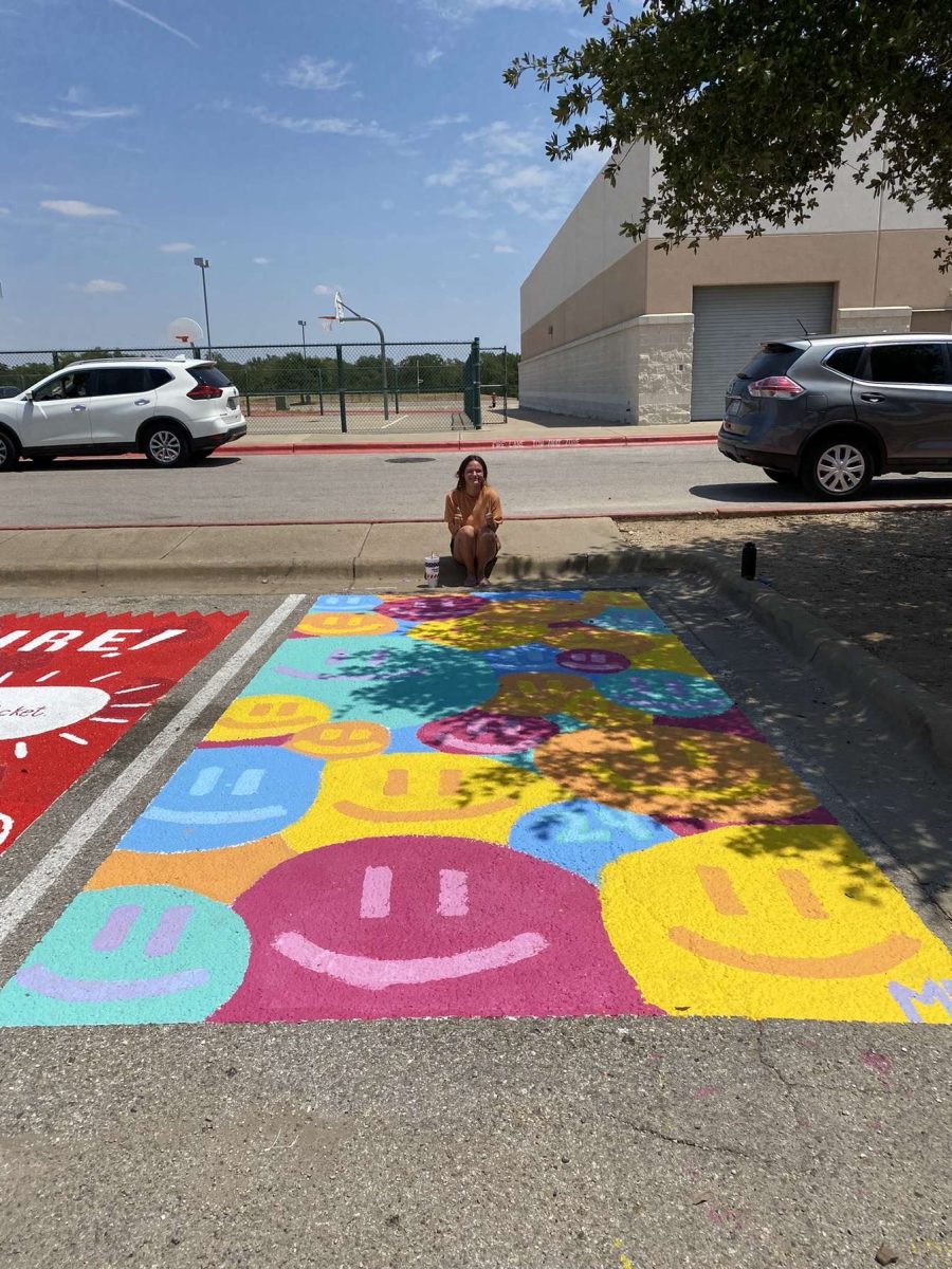 Senior, Morgan Hicks poses with her completed parking spot for the 2023-2024 school year.