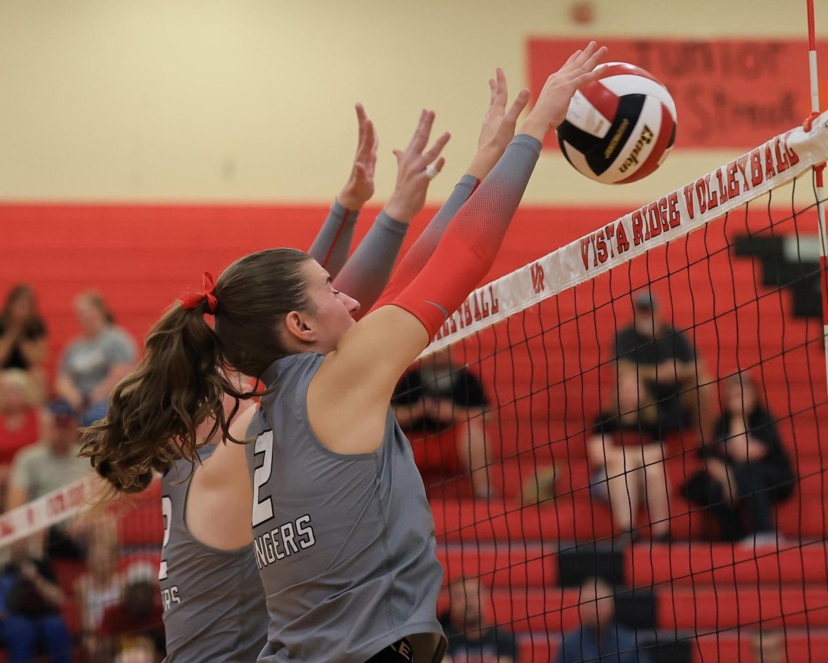 Senior, Avery Place as she jumps to block the ball.