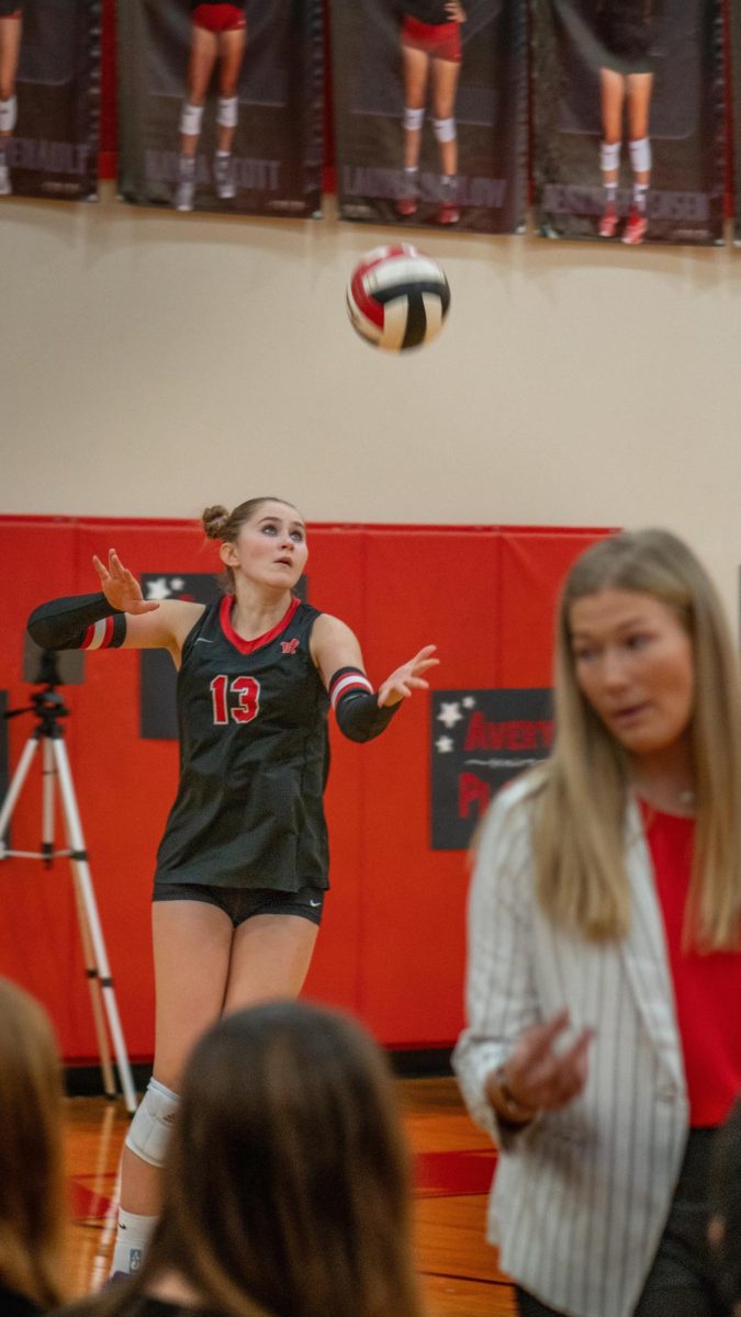 Junior Opposite Hitter Jennavee Jensen give the ball a toss as she aim precisely to serve the ball.
