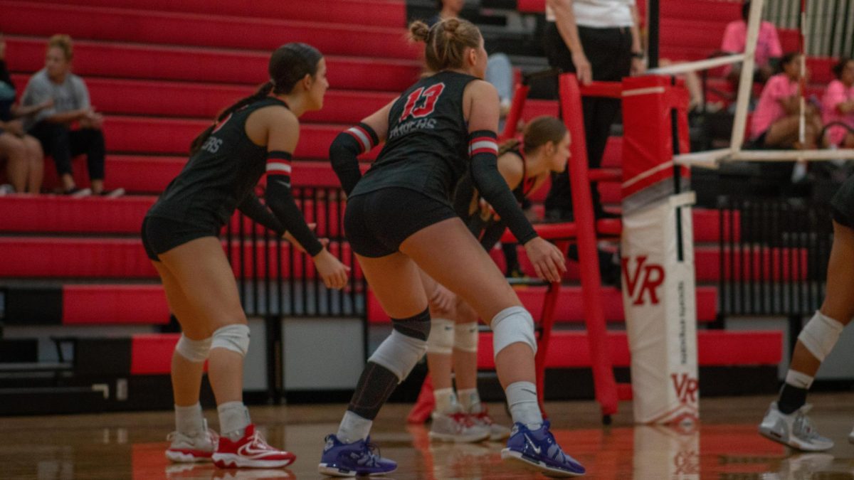 Junior Opposite Hitter Jennavee Jensen staying low getting ready to receive a weak spike from the McNeil Volleyball team.