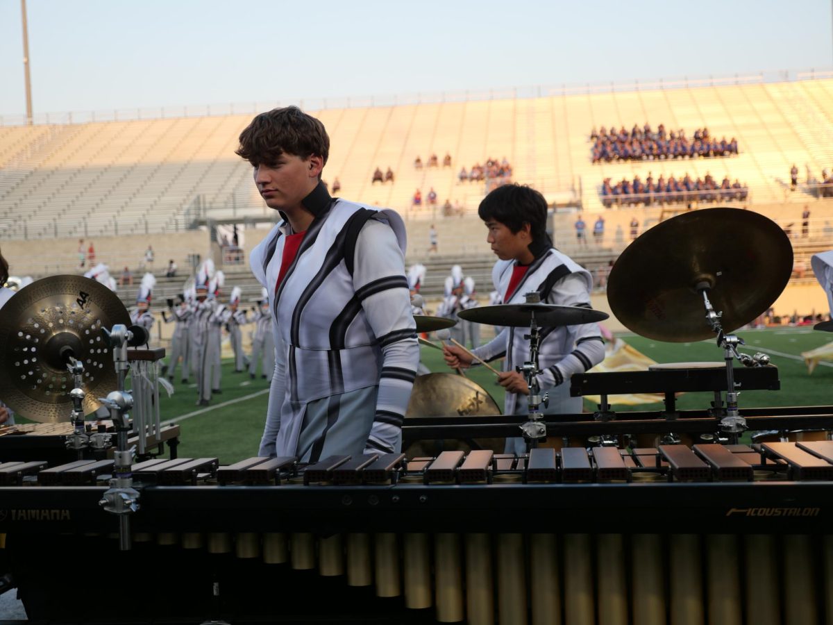 Senior Luke Collins intensely focuses on his music during halftime of a football game.