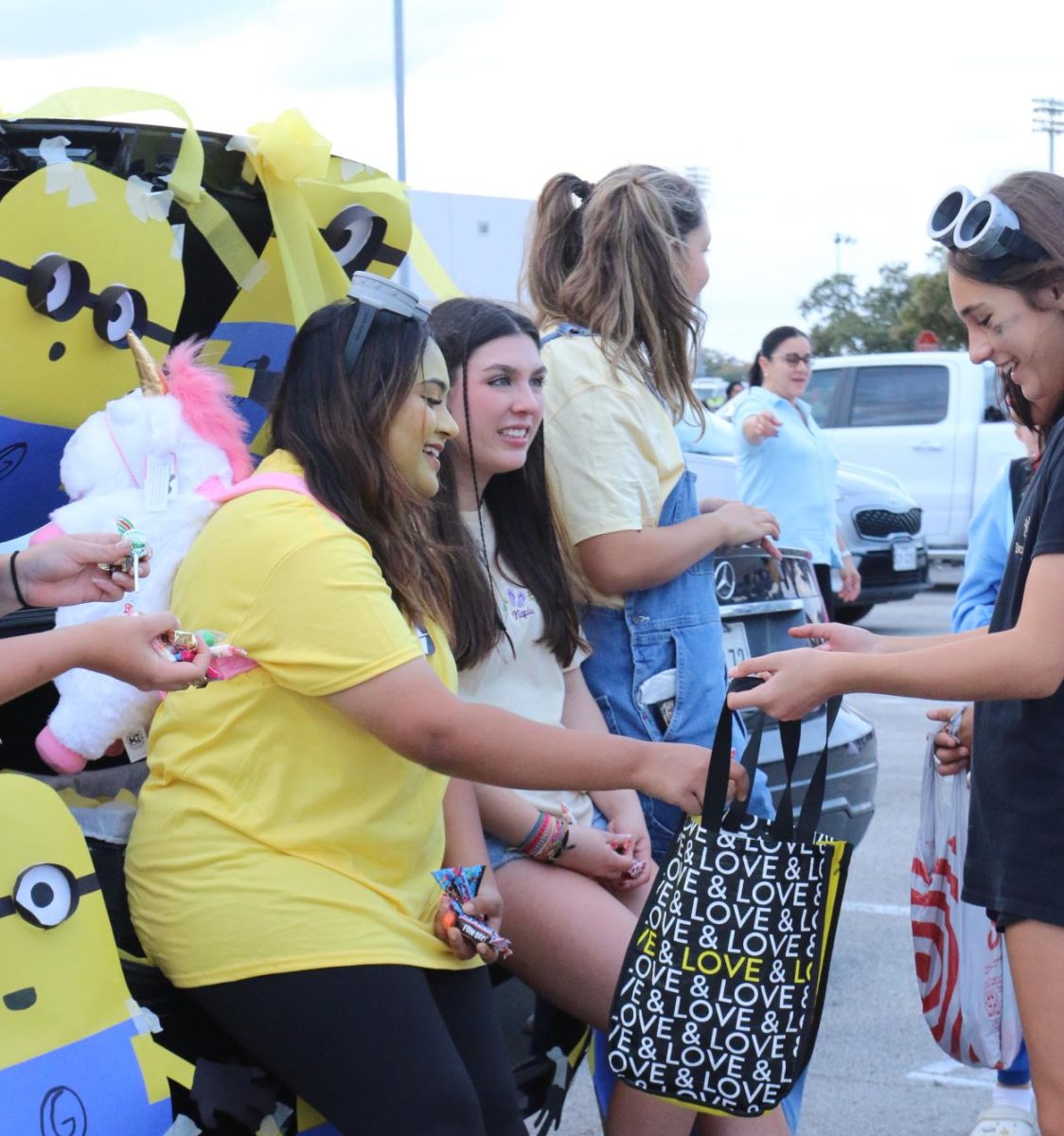 FCCLA president Hibah Mirza hands candy out to kids in their Minions-themed trunk during the annual Trunk-or-Treat celebration on Oct. 30.